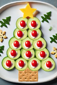 a christmas tree made out of cucumbers and crackers on a white plate