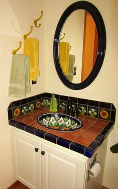 a bathroom sink sitting under a round mirror