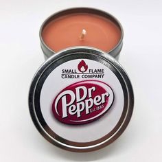 a small tin of lip bale sitting on top of a white table next to a candle