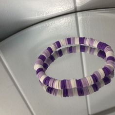 two purple and white bracelets sitting on top of a counter