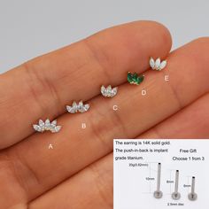 four pairs of diamond studs are shown in the palm of someone's hand