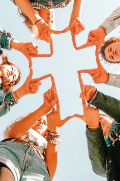 a group of people standing in a circle with their hands on top of each other