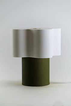 a green and white lamp on a white surface