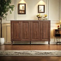 a large wooden cabinet sitting on top of a hard wood floor next to a potted plant