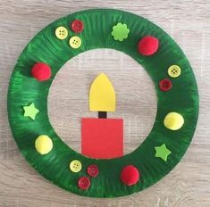 a paper plate wreath with a lit candle on it