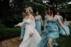 a group of women in dresses walking across a field