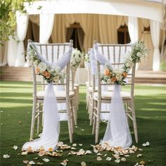 two chairs with white sashes and flowers on them