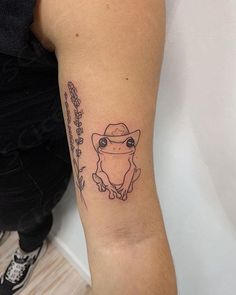 a small tattoo on the arm of a person wearing a hat and holding a cane