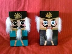 two wooden nutcrackers are sitting on a red blanket