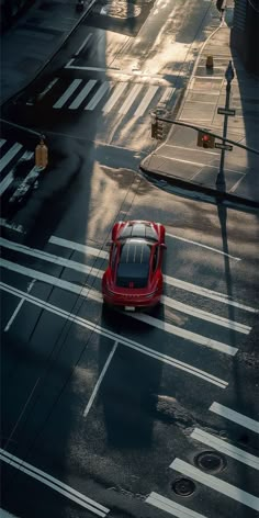 a red sports car is driving down the street