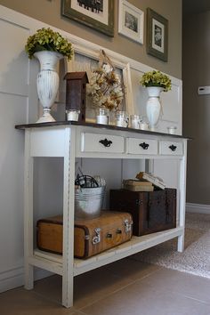 a white table topped with lots of vases and other things on top of it