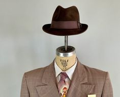 "You'll need this snazzy 1950's fedora to complete your look and turn your suit into an outfit! This fur felt fedora is chocolate brown with a cedar brown grosgrain ribbon band. It has a leather hat band and is fully lined. Made by \"Biltmore\" and sold by \"The Hat Guys\" in Oakland California. This hat is in great vintage condition with no holes, stains, or odors to note. Marked Size: 7 Inner circumference: 22\" Length (at longest point): 11.5\" Width (at widest point): 10.5\" Crown Height: 4\ Brown Fitted Fedora For Kentucky Derby, Formal Fitted Brown Fedora, Vintage Fitted Fedora For Fall, Fitted Vintage Brown Fedora, Fitted Vintage Fedora For Fall, Vintage Brown Fedora For Formal Occasions, Retro Fitted Brimmed Fedora, Vintage Fedora With Wide Brim, Retro Fitted Fedora With Brim