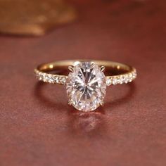 an oval cut diamond ring with pave set shoulders