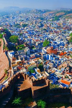 an aerial view of the blue city of jodhpur with mountains in the background