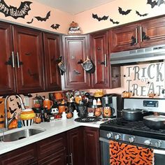 a kitchen decorated for halloween with bats and pumpkins