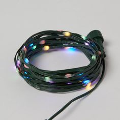 a string of multi - colored lights on a white background with the cord connected to it