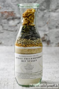 a bottle filled with lots of food on top of a white countertop next to a brick wall