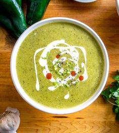 a white bowl filled with broccoli soup on top of a wooden table