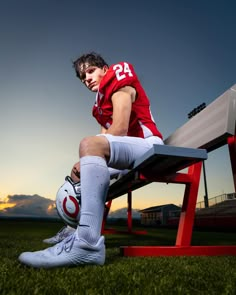 a man sitting on top of a bench wearing a football uniform