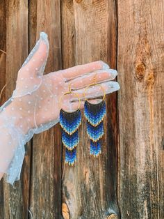 "🌊🌞 Dive into summertime with these stunning Blue Gold Ombre Beaded Fringe Earrings! These handwoven American style earrings are inspired by the vibrant colors of the ocean and make the perfect gift for any beach lover. Crafted from high-quality seed beads, these earrings feature a beautiful ombre design that fades from blue to gold, a symbol of the shining sun reflecting off the ocean.  These Blue Gold Ombre Beaded Fringe Earrings are perfect for adding a pop of color to any outfit. Their unique design will set you apart from any crowd. Whether you're heading to the beach or to a summer party, these earrings are the perfect accessory to complete your look. So why wait? Order your Blue Gold Ombre Beaded Fringe Earrings today and add a touch of ocean-inspired beauty to your style!🌊 🔎Siz Beaded Fringe Dangle Jewelry For Beach, Beach Dangle Jewelry With Beaded Fringe, Handwoven Gold Jewelry For Summer, Summer Jewelry With Beaded Fringe And Round Beads, Gold Beaded Fringe Earrings For Beach, Gold Beach Jewelry With Beaded Fringe, Blue Handwoven Dangle Jewelry, Handmade Chandelier Earrings For Summer Beach Occasions, Summer Gold Beaded Fringe Jewelry