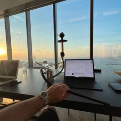 a person sitting at a desk with a laptop on it and a view of the ocean