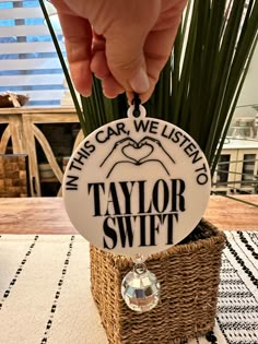 a person is holding a badge that says, in this car we listen to taylor swift