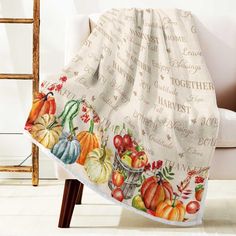 a white chair with a fall themed blanket on it