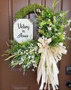 a wreath is hanging on the front door with a sign that says victory in jesus