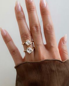 a woman's hand with three diamond rings on top of her left hand,