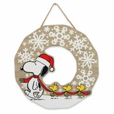 a wooden christmas ornament with a snoopy dog and snowflakes on it