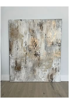 an abstract painting on the wall in a room with wood flooring and white walls