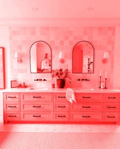 a bathroom with two sinks and mirrors on the wall, pink hues in the room