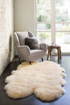 a living room with a chair and sheepskin rug