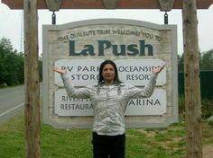 a woman standing in front of a sign for la push