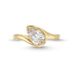 a yellow gold ring with a pear shaped diamond in the center and a curved band