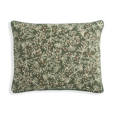 a green pillow with white and brown flowers on it