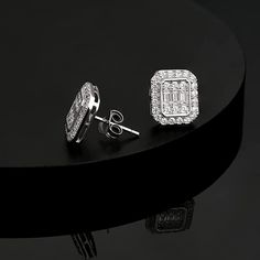 These handsome men's earrings showcase a brilliant array of round-cut and radiant-cut stones. The square-shaped earrings are crafted in sterling silver.Weight: 2.5 gWidth: 10 mmHeight: 11 mmMaterial: 925 SilverStone Type: Jeulia® StonePlating Color: Silver Silver Earrings With Baguette Diamonds, Luxury Silver Earrings For Men, Sterling Silver Earrings With Baguette Diamonds For Gifts, Silver Rectangular Jewelry With Halo Design, Sterling Silver Earrings With Baguette Diamonds As A Gift, Silver Sterling Earrings With Baguette Diamonds, Silver Rectangular Earrings Fine Jewelry, Rectangular Silver Diamond Earrings, Silver Rectangular Classic Diamond Earrings