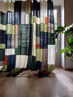 a room with wood flooring and a curtain that has different colored squares on it