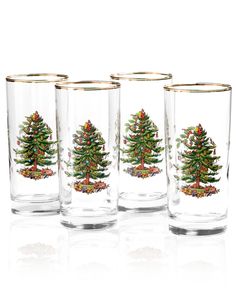 three glasses with christmas trees on them are lined up against a white background, one has gold rims and the other is clear