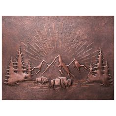 a metal plaque with animals and mountains in the background