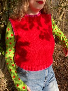 Handmade sweater vest made to measure in lush red and pink. Hand knitted by me from 100% wool so it's super warm and stretchy.  Mock neck style around the neck for extra cosiness. Looks great styled over a long sleeve top, a dress or even layered over another jumper!  Can be ordered with or without the heart embroidery- please select from the drop down menu. Please allow 3-4 weeks for your order to be made and dispatched. Measurements I will need BEFORE I can start making your order: - Bust (widest part of the chest)  - Length you would like the vest (from top of shoulder to hem) If you would like different colours just send me a message and we can discuss options!  Free worldwide delivery.  Hand wash only, dry flat. Fitted Winter Sweater Vest, Fitted Sweater Vest For Winter, Red Sleeveless Winter Vest, Pink Knitted Sweater Vest For Winter, Fitted Knit Vest For Winter, Red Wool Vest For Winter, Pink Crew Neck Vest For Spring, Knitted Stretch Sweater Vest For Winter, Chunky Knit Sleeveless Winter Vest