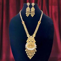 This stunning gold-plated necklace set is a masterpiece of traditional Indian craftsmanship, featuring an intricately designed Lakshmi pendant with detailed temple motifs. The antique finish and the exquisite beadwork add to its royal charm, making it the perfect choice for bridal wear or festive occasions. The necklace is adorned with colorful stones, adding a touch of elegance and grandeur. This set includes: - A temple-style necklace with Lakshmi pendant - Matching intricately designed jhumka earrings Key Features: - Material: High-quality alloy with gold plating - Design: Temple jewelry with intricate Lakshmi motif - Occasion: Ideal for weddings, traditional events, and festive wear - Package includes: 1 Necklace and 1 pair of matching earrings - Care Instructions: Keep away from water Temple Motifs, Lakshmi Temple, Lakshmi Pendant, Temple Necklace, Necklace Set With Earrings, Colorful Stones, Temple Jewelry, Charm Making, Festive Wear