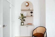 a chair sitting next to a shelf with a potted plant on it