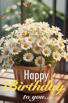 a basket filled with daisies sitting on top of a wooden table