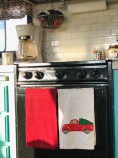 two kitchen towels hanging on an oven