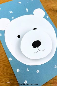 a paper cut out of a polar bear on top of a blue card with white dots