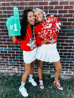 two girls in red shirts and white skirts posing for the camera with cheerleaders