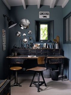 an old fashioned desk and chair in a room with blue walls, white beams and wooden floors