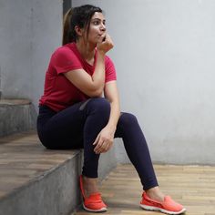 a woman is sitting on the steps with her hand in her mouth