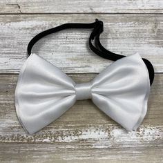 "Adults/Teens Elastic Suspender, Bow-tie All dimensions are approximate only Suspender Dimensions: Wide : 1.5\" (3.81cm) Adjustable from 25\" 63.5cm - 38\" (96.52cm) Bow Tie Dimensions: Length: 12cm (4.7 inches) Height (Widest Point): 6cm (2.36 inches) Height (Narrowest Point): 2.3cm (0.90 inches) Length of Bow Tie Strap at full length: 48cm (18.89 inches)" Fitted Pre-tied Bow For Party, Classic White Bow Tie For Wedding, White Bow Tie For Black-tie Events, Fitted Pre-tied Tie For Party, White Bow Tie For Black Tie Events, Classic White Bow With Ties, Classic White Bow Ties, Adjustable White Bow For Wedding, White Adjustable Bow For Wedding